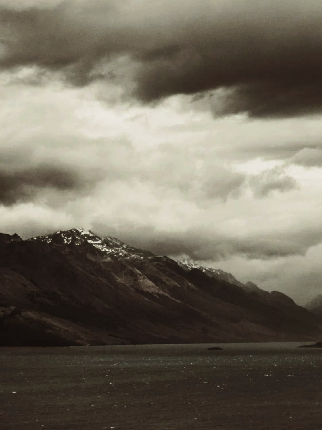 Storm cloud gathering over a mountain lake.