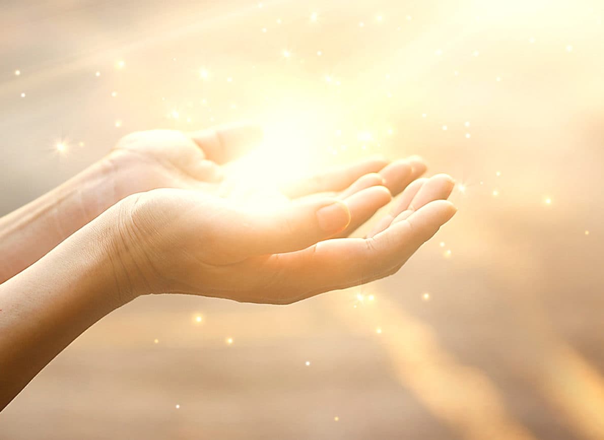 Two open hands cupped together with light falling into them.